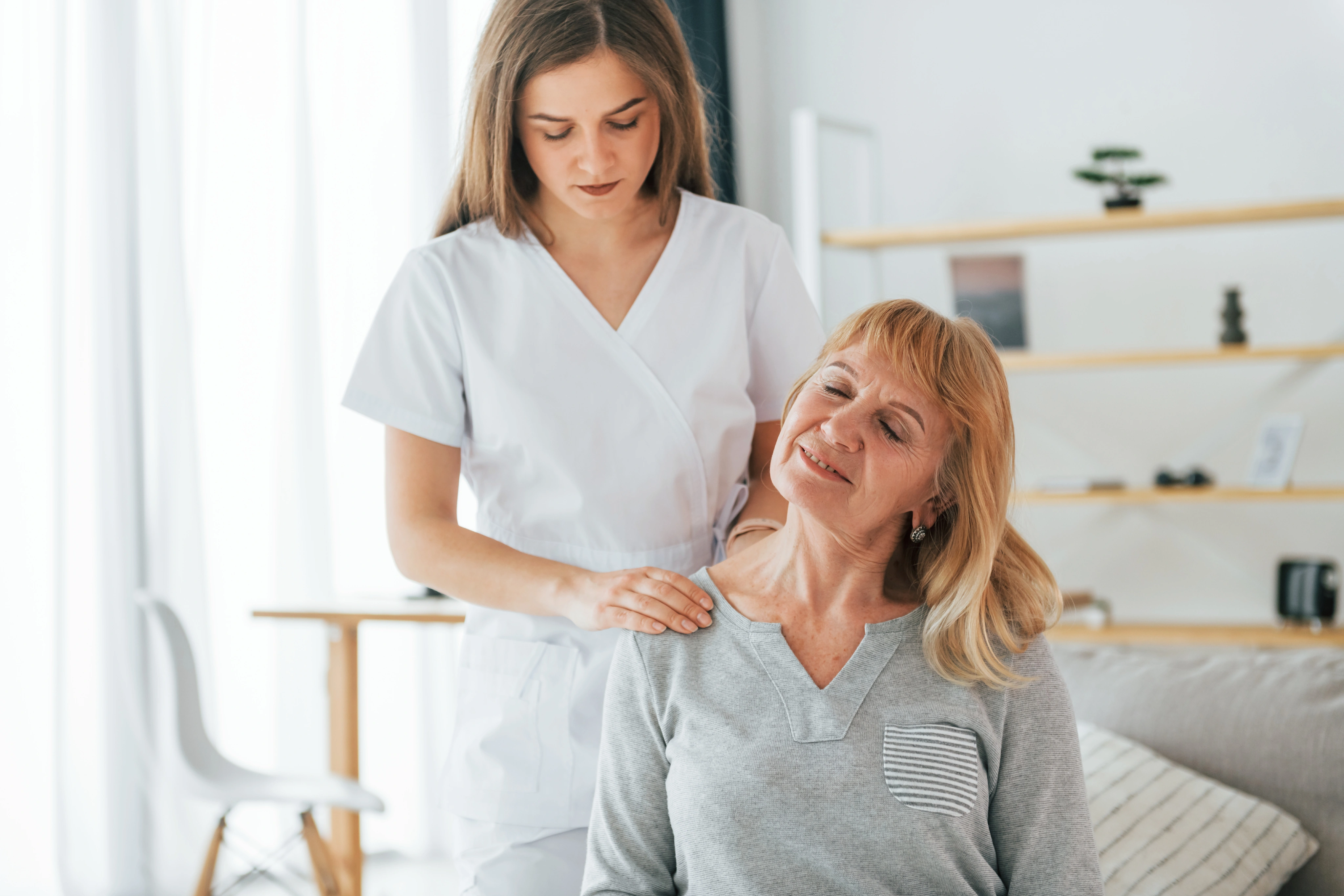 Practitioner assessing a woman’s shoulder